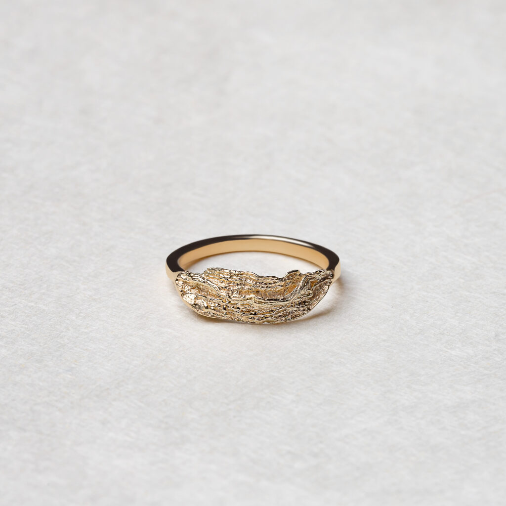 The Ocean Wave Ring featuring elegant curves and a flowing design, crafted from recycled 14k yellow gold