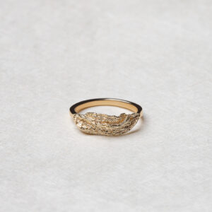 The Ocean Wave Ring featuring elegant curves and a flowing design, crafted from recycled 14k yellow gold