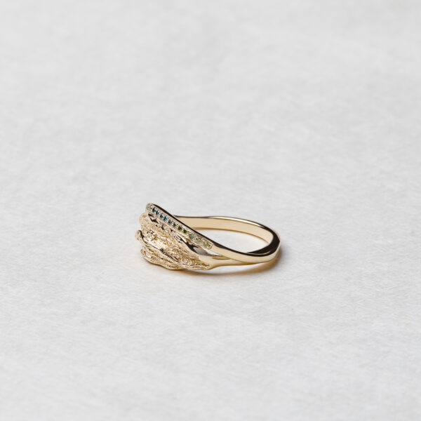 Side view of the Ocean Wave ring, featuring a flowing band of recycled 14k gold with naturally colored diamonds in a gradient reflecting the colors of the sea.